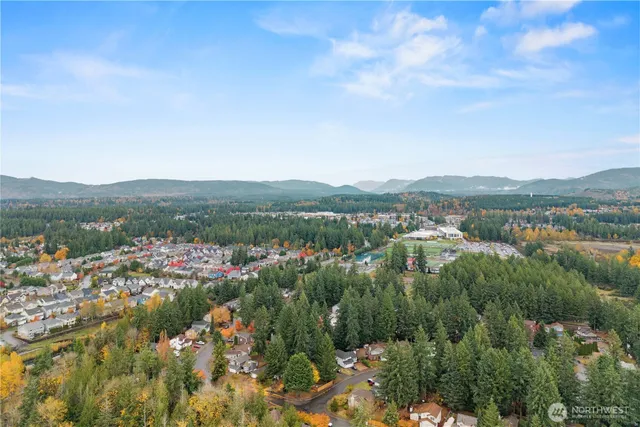 an aerial view of residential house with outdoor space and trees all around