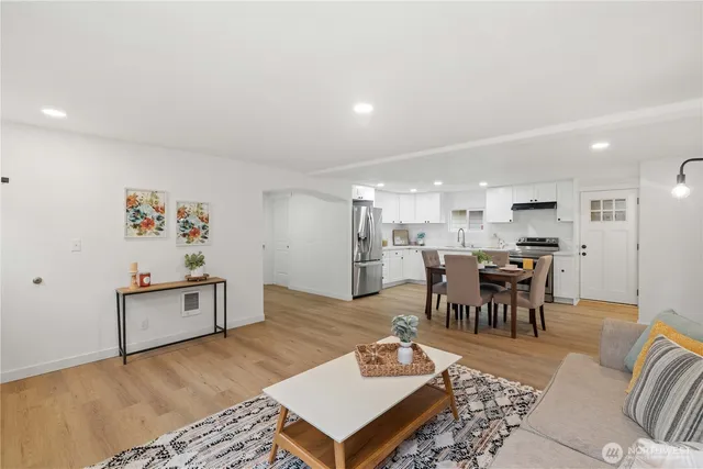 a living room with furniture and a dining table with kitchen view