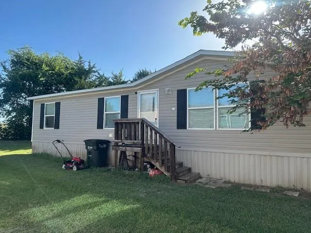 a view of a house with a yard and a wooden deck