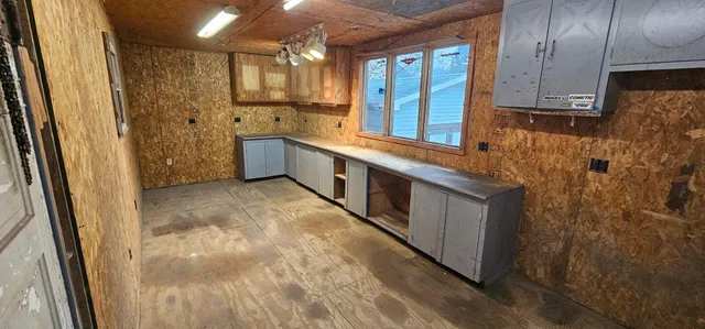 a large white kitchen with granite countertop a sink