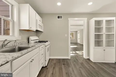 a kitchen with sink cabinets and wooden floor