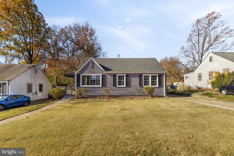 a front view of a house with yard and trees