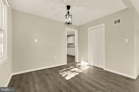 a view of empty room with wooden floor and window