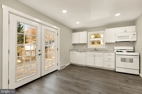 a kitchen with wooden floors and white appliances