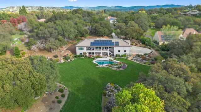 an aerial view of a house with yard and green space