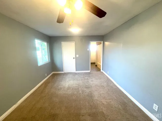 an empty room with windows and cabinet