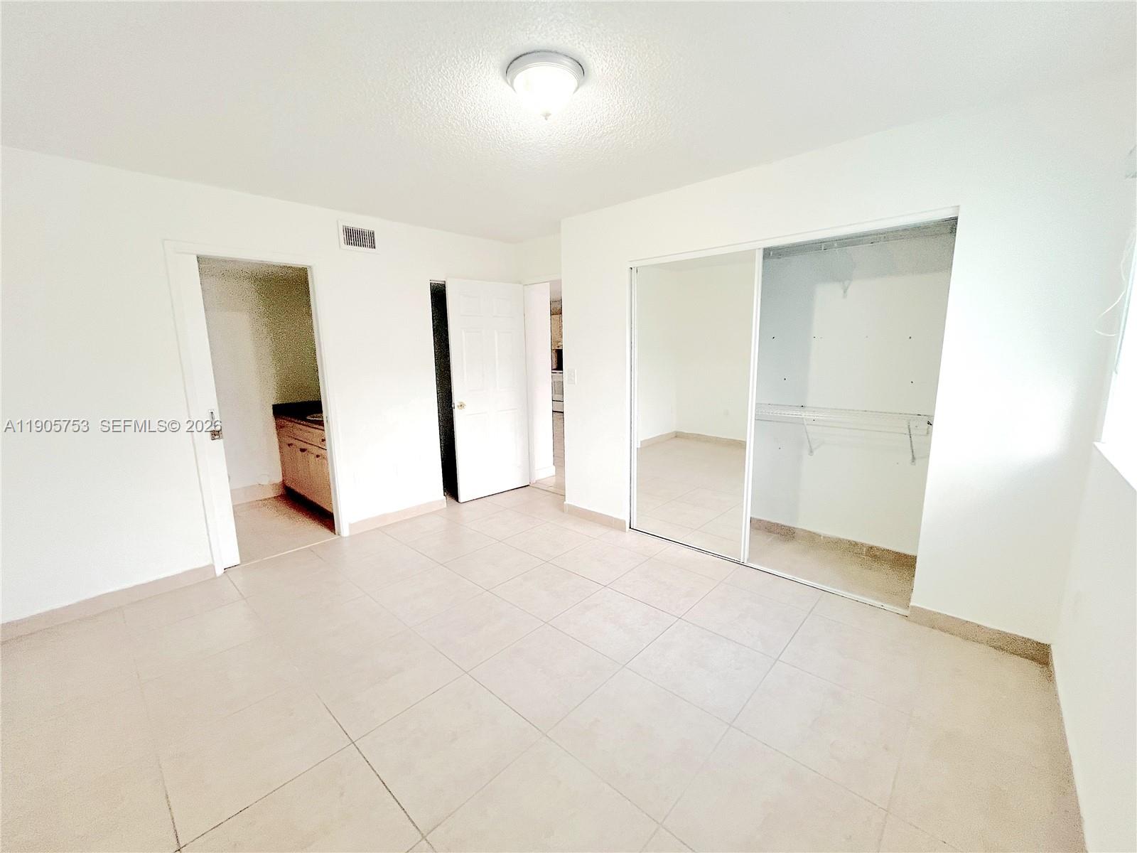 2740 West 63rd Street, Unit 104 Hialeah, FL 33016 - Photo 27 of 29 an empty room with closet and mirrors
