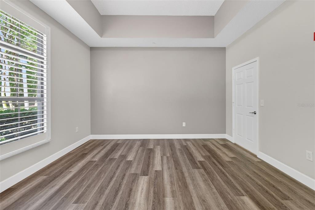 701 Westpark Way, Unit 101 Celebration, FL 34747 - Photo 30 of 69 a view of an empty room with wooden floor and a window