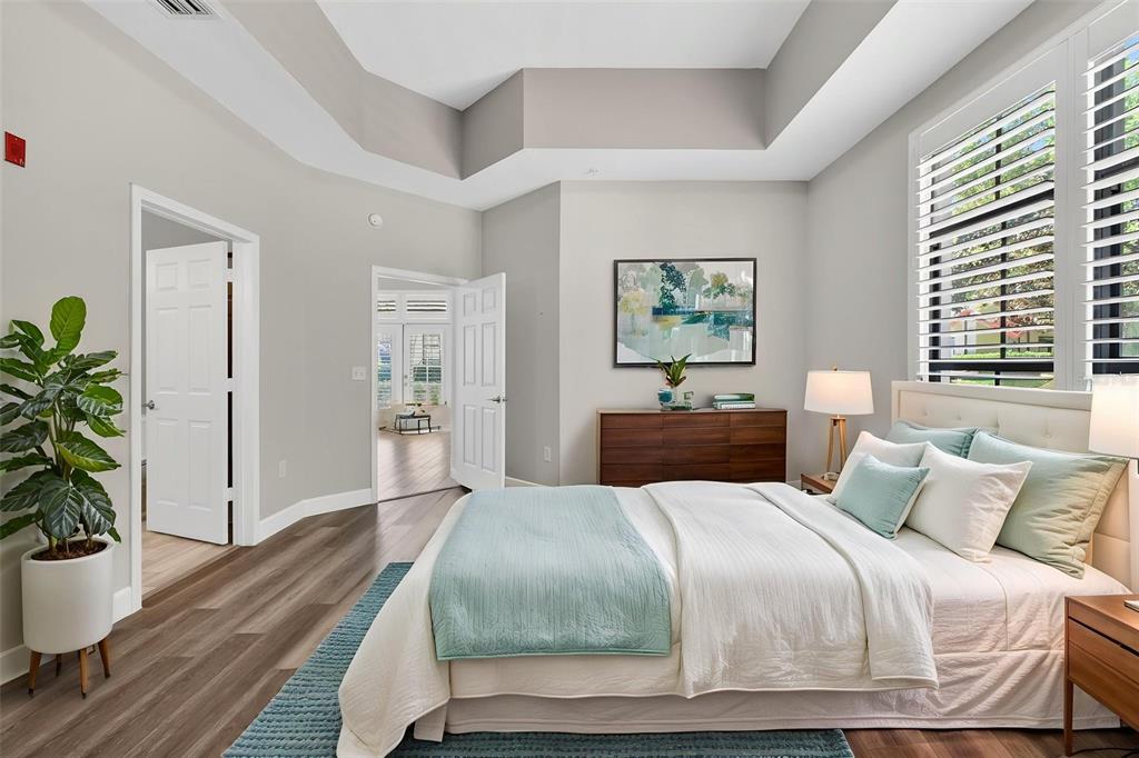 701 Westpark Way, Unit 101 Celebration, FL 34747 - Photo 31 of 69 a bedroom with a large bed and a potted plant
