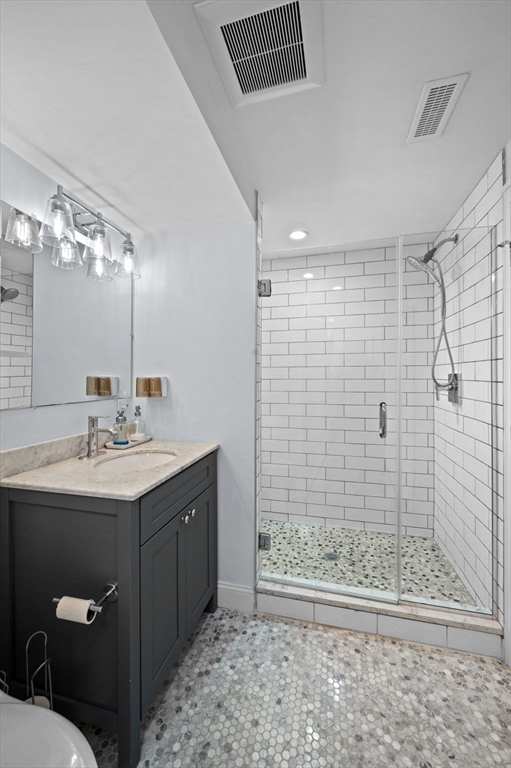 9 Hanover Court, Unit 1 Marblehead, MA 01945 - Photo 20 of 38 a bathroom with a sink a toilet a mirror and shower