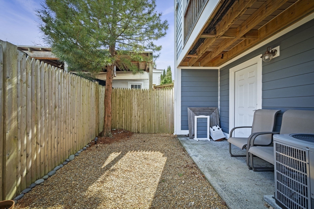 9 Hanover Court, Unit 1 Marblehead, MA 01945 - Photo 30 of 38 a view of a patio with table and chairs and wooden fence