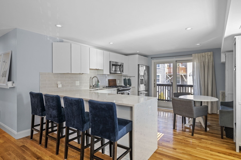 9 Hanover Court, Unit 1 Marblehead, MA 01945 - Photo 8 of 38 a kitchen with a dining table chairs and white cabinets