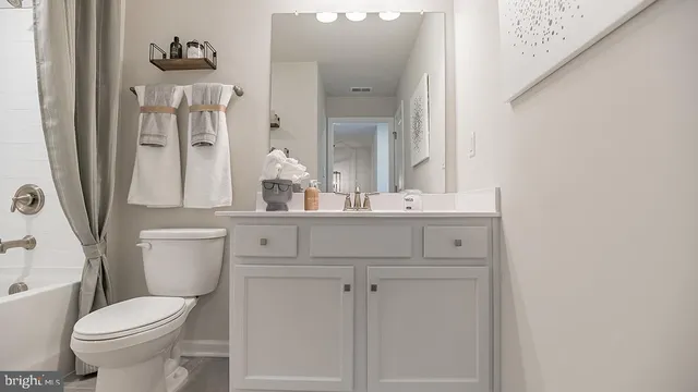 a bathroom with a sink vanity mirror and toilet