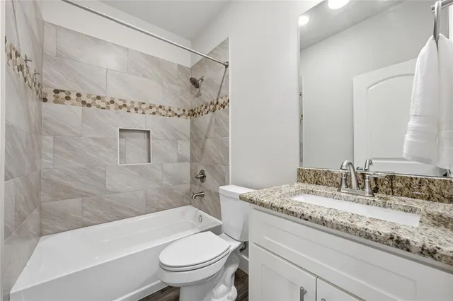a bathroom with a granite countertop sink toilet and shower
