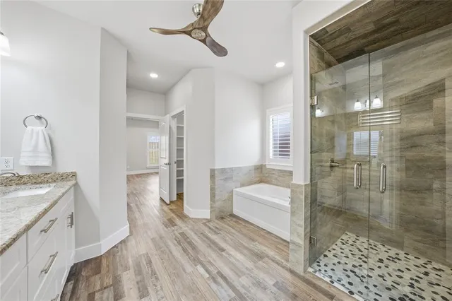 a bathroom with a double vanity sink a toilet and shower