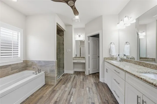 a spacious bathroom with a granite countertop sink mirror and a bathtub