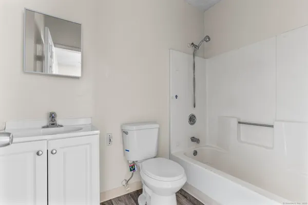 a bathroom with a granite countertop toilet a sink and a bathtub