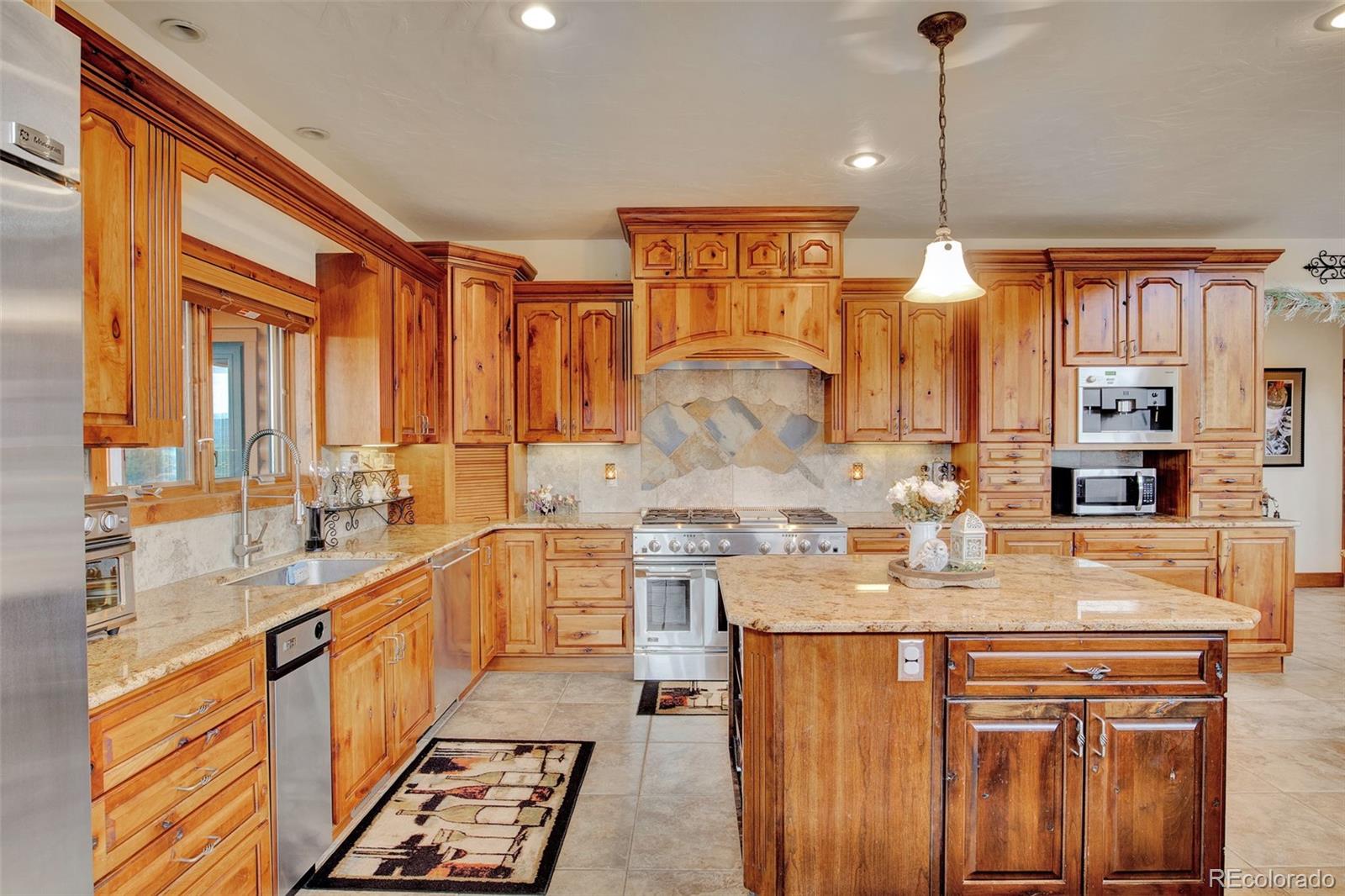 400 Copper Canyon Road Canon City, CO 81212 - Photo 13 of 50 a large kitchen with stainless steel appliances granite countertop a sink a stove and a wooden cabinets