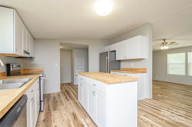 a kitchen with a stove a sink a refrigerator and cabinets