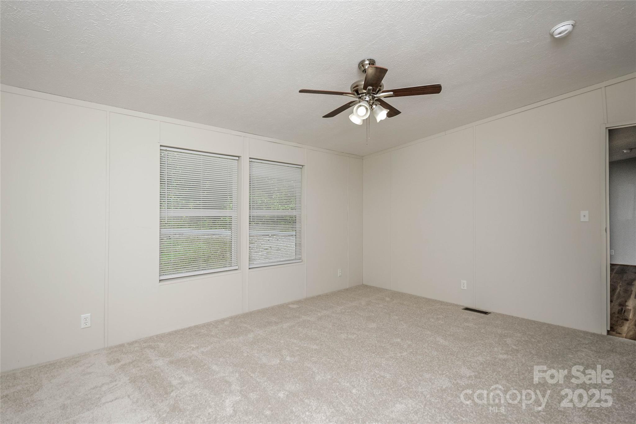 1361 Pleasant Grove Church Road Hendersonville, NC 28739 - Photo 27 of 48 an empty room with a window and a fan