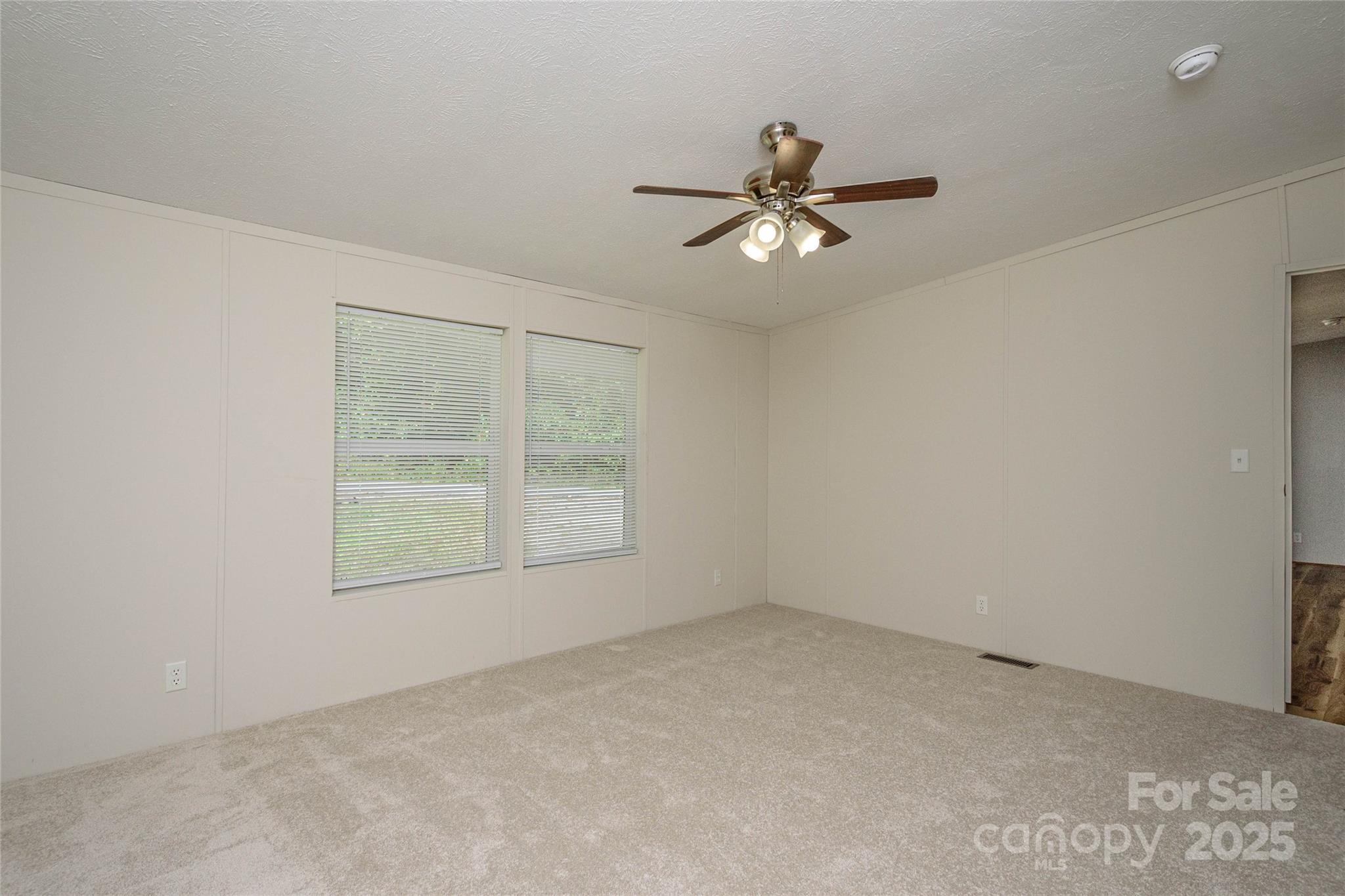 1361 Pleasant Grove Church Road Hendersonville, NC 28739 - Photo 28 of 48 an empty room with a window and a fan