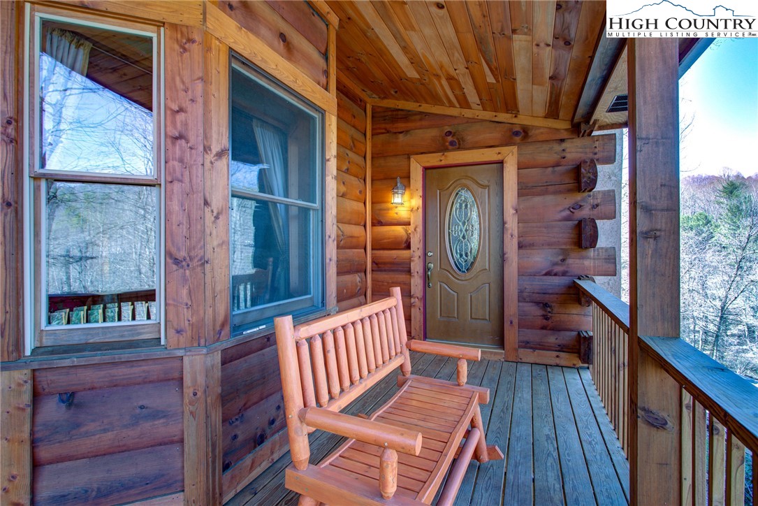 186 Riversound Drive Banner Elk, NC 28604 - Photo 17 of 45 a view of a porch with wooden floor and outdoor seating
