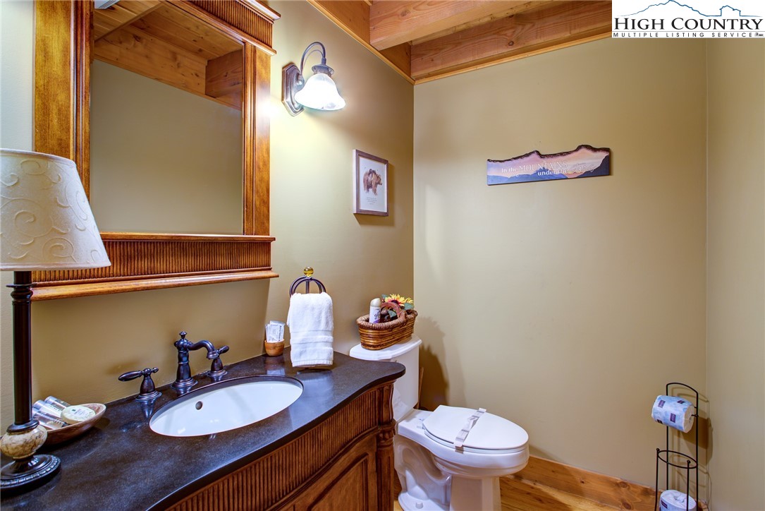 186 Riversound Drive Banner Elk, NC 28604 - Photo 34 of 45 a bathroom with a granite countertop toilet a sink and a mirror