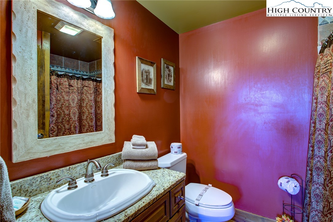 186 Riversound Drive Banner Elk, NC 28604 - Photo 8 of 45 a bathroom with a granite countertop toilet sink and mirror