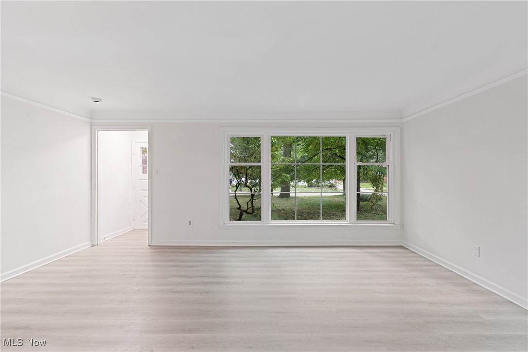 1057 Renfield Road Cleveland Heights, OH 44121 - Photo 4 of 30 Empty room featuring crown molding and light hardwood / wood-style floors