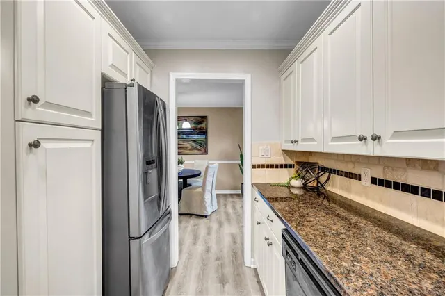 a kitchen with stainless steel appliances granite countertop a refrigerator and a stove