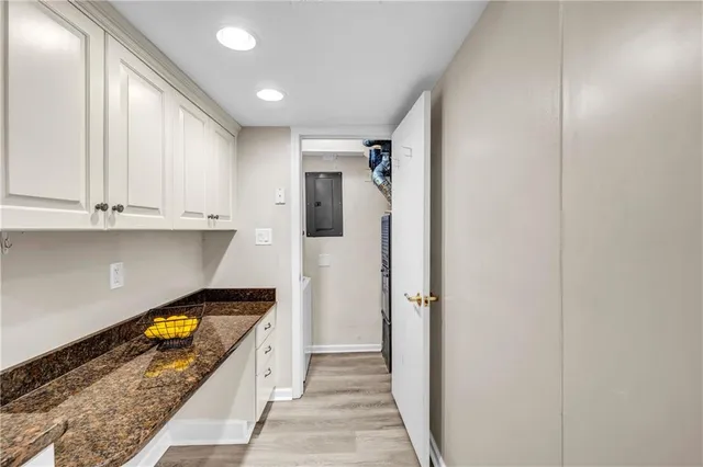 a large white kitchen with stainless steel appliances granite countertop a refrigerator and a sink