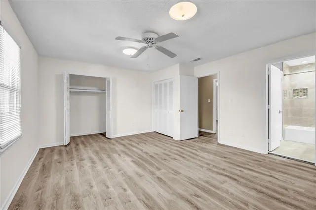 a view of an empty room with wooden floor and window