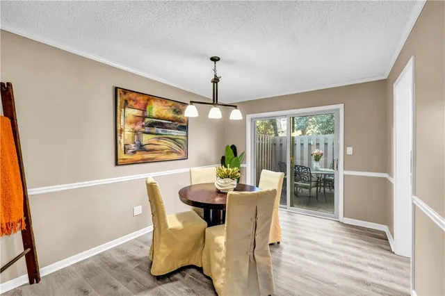 a dining room with furniture a chandelier and wooden floor