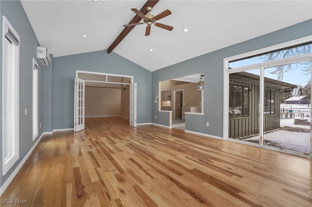 1094 San Raphael Drive Akron, OH 44333 - Photo 14 of 50 Unfurnished living room featuring light wood-style floors, french doors, ceiling fan, and a wall mounted AC
