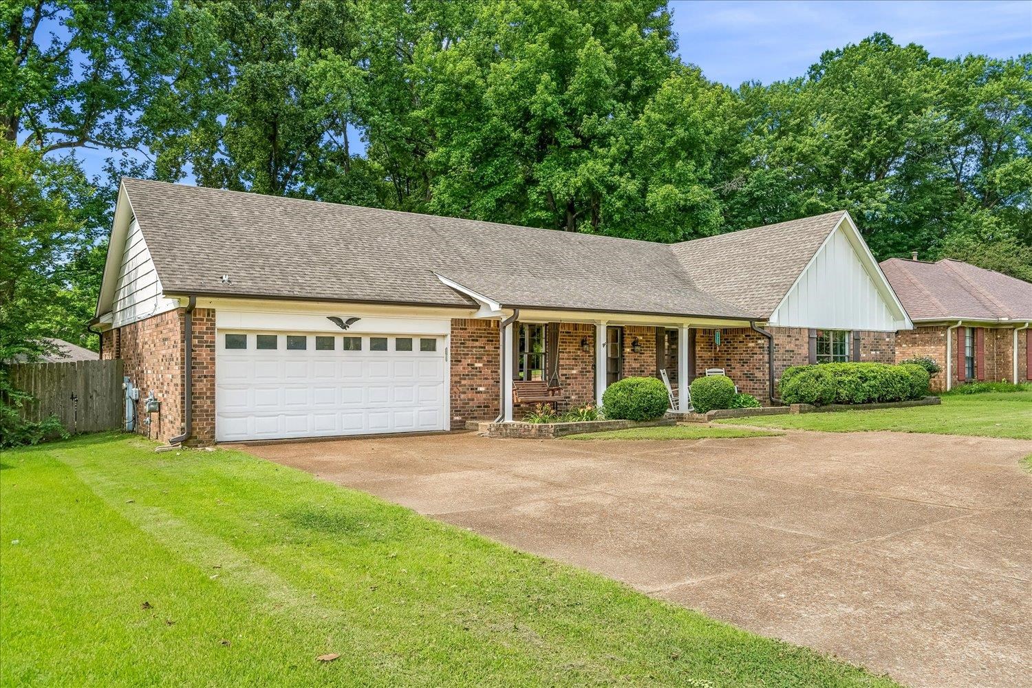 5711 Yale Road Bartlett, TN 38134 - Photo 23 of 29 Brick exterior featuring a two-car garage, mature landscaping, and a covered porch entry