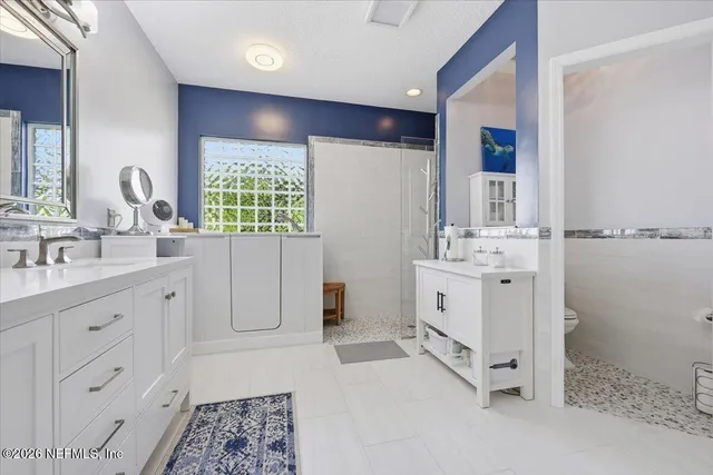 a spacious bathroom with a granite countertop sink a mirror and a