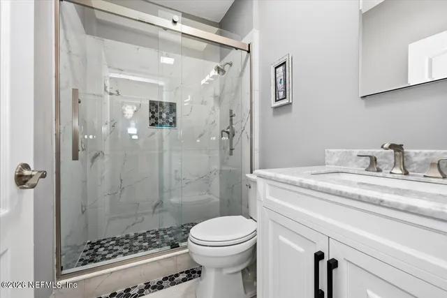 a blue couch sitting in a living room with furniture and a flat screen tv