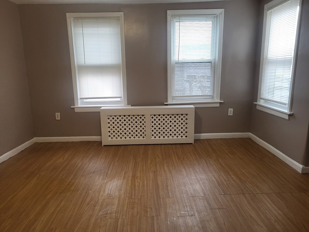 89 Oak Street Fall River, MA 02720 - Photo 21 of 39 an empty room with wooden floor and windows