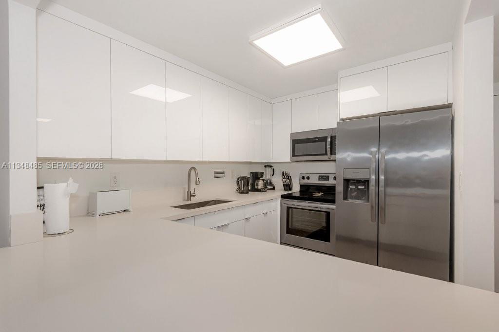 2301 Collins Avenue, Unit 927 Miami Beach, FL 33139 - Photo 13 of 30 a kitchen with a refrigerator sink and stove