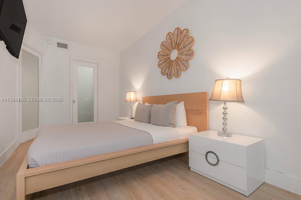 2301 Collins Avenue, Unit 927 Miami Beach, FL 33139 - Photo 14 of 30 a bedroom with a bed and a chandelier