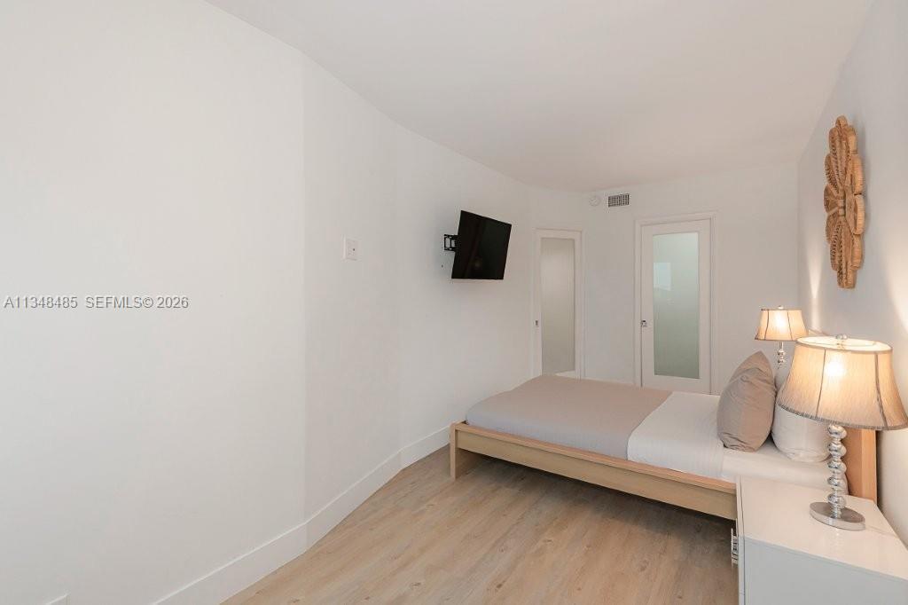 2301 Collins Avenue, Unit 927 Miami Beach, FL 33139 - Photo 19 of 30 a bedroom with a bed and a flat screen tv