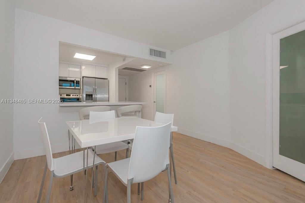 2301 Collins Avenue, Unit 927 Miami Beach, FL 33139 - Photo 21 of 30 a dining room with furniture and wooden floor