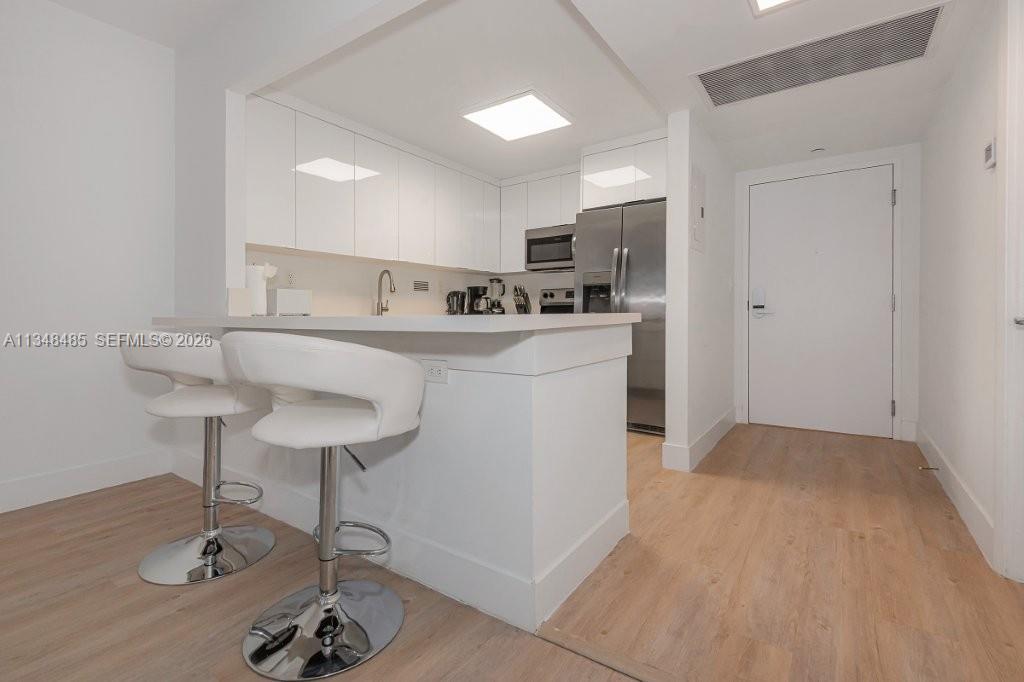 2301 Collins Avenue, Unit 927 Miami Beach, FL 33139 - Photo 25 of 30 a living room with stainless steel appliances furniture a rug and a kitchen view