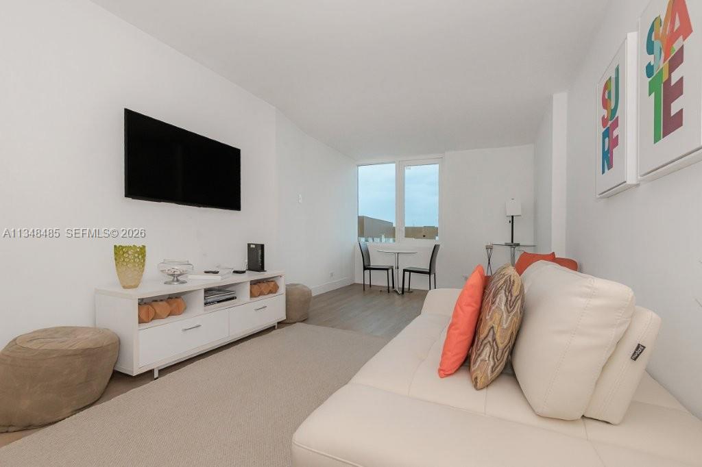 2301 Collins Avenue, Unit 927 Miami Beach, FL 33139 - Photo 4 of 30 a living room with furniture and a flat screen tv