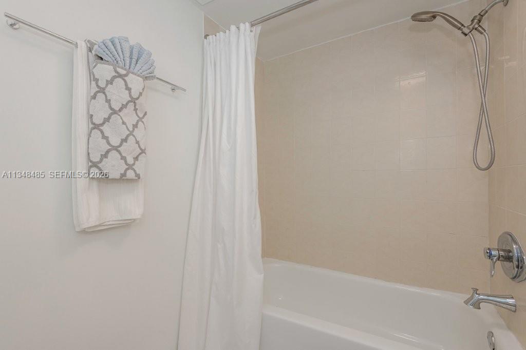 2301 Collins Avenue, Unit 927 Miami Beach, FL 33139 - Photo 9 of 30 a bathroom with a shower curtain and a shower