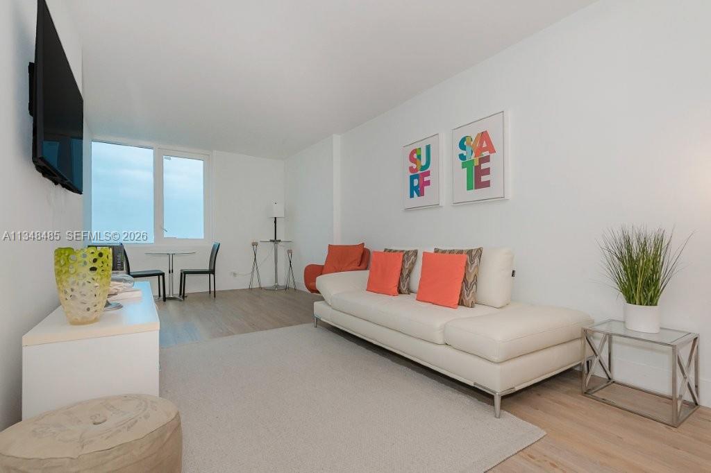 2301 Collins Avenue, Unit 927 Miami Beach, FL 33139 - Photo 10 of 30 a living room with furniture and a flat screen tv