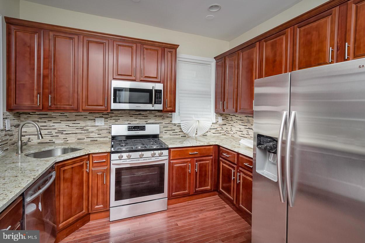 2903 Allendale Road Baltimore, MD 21216 - Photo 3 of 30 a kitchen with stainless steel appliances granite countertop wooden cabinets and a stove top oven