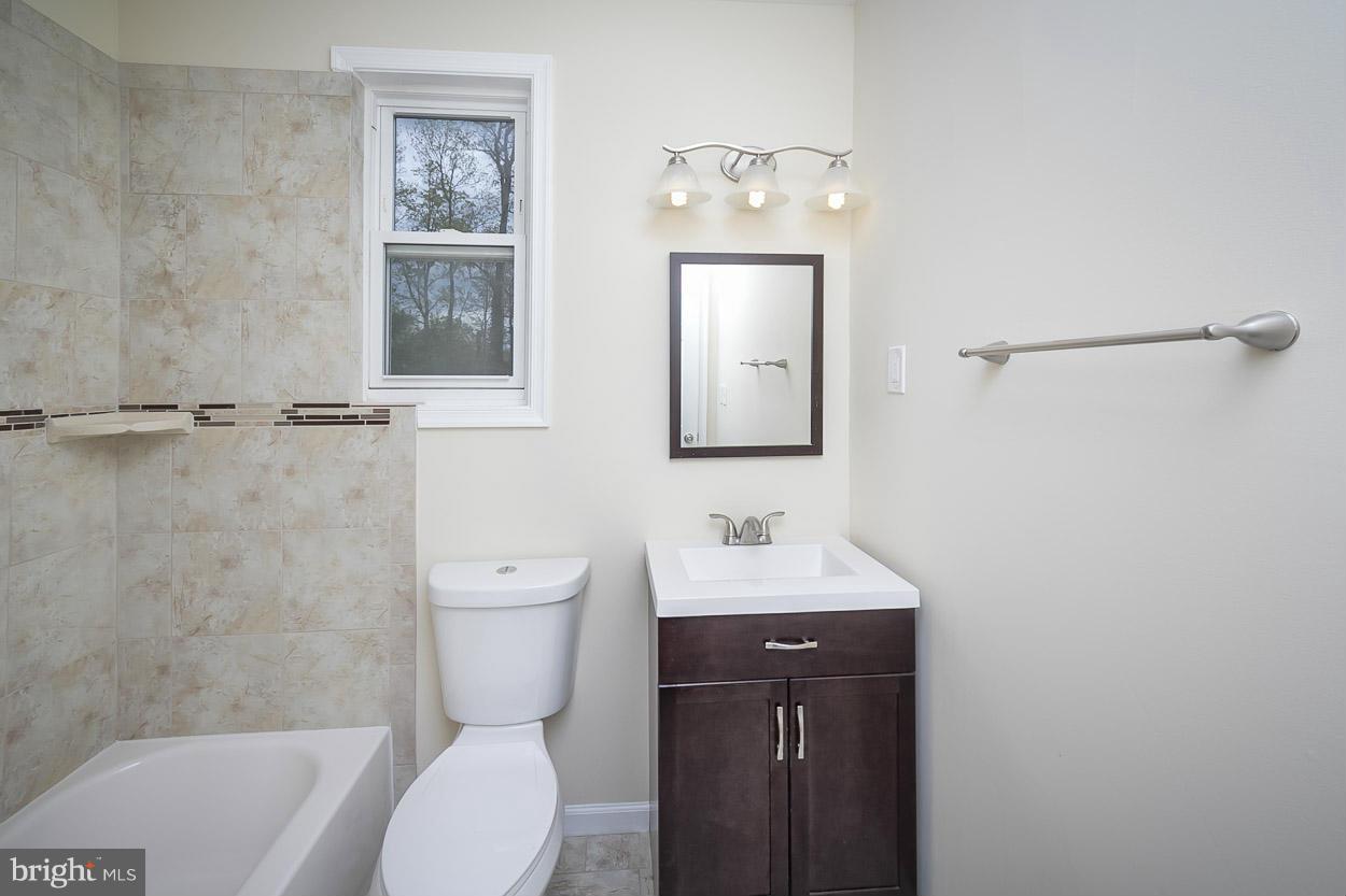 2903 Allendale Road Baltimore, MD 21216 - Photo 22 of 30 a bathroom with a toilet a sink and mirror