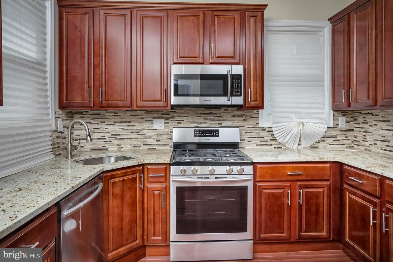 2903 Allendale Road Baltimore, MD 21216 - Photo 5 of 30 a kitchen with granite countertop wood cabinets and stainless steel appliances