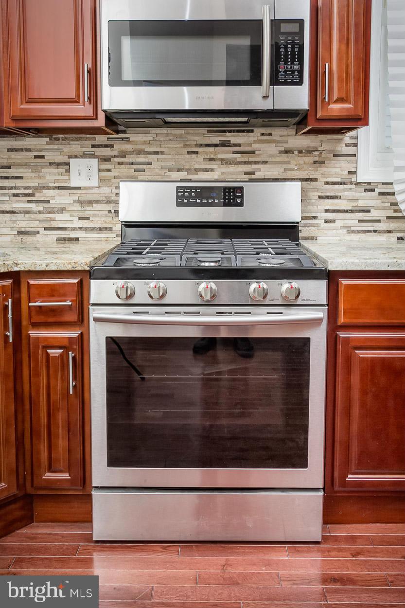 2903 Allendale Road Baltimore, MD 21216 - Photo 7 of 30 a stove top oven sitting inside of a kitchen and granite counter tops